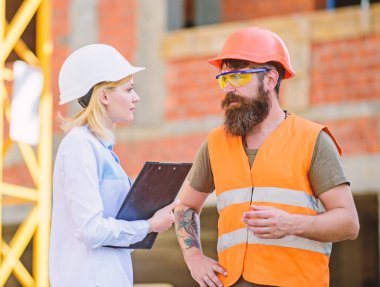 Kadın mühendis ve sakallı acımasız builder İnşaat ilerleme tartışmak. İnşaat Proje yönetimi. Bina endüstriyel proje. İnşaat endüstri kavramı. İlerleme projeyi tartışmak