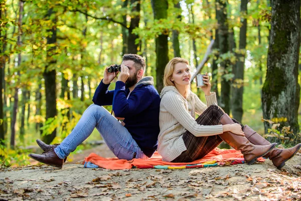 Pihen a parkban együtt. Boldog szerető pár pihentető Park együtt. Pár szerelmes turisták pihentető piknik takaró. Ember távcső és a nő fém bögre élvezik Természetvédelmi Park. Park-dátum — Stock Fotó