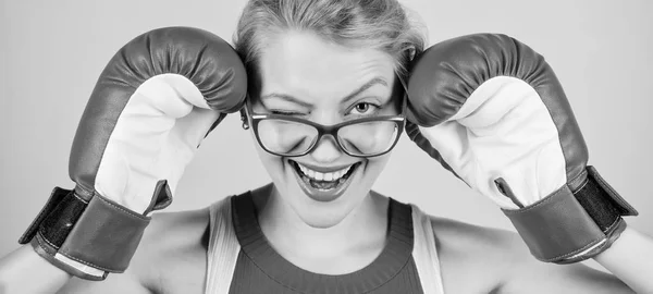 Una mujer fuerte parece un desafío a los ojos y le da un guiño. El boxeo la hace súper apta. Mujer sexy en gafas y guantes de boxeo. Bonito boxeador. Chica atlética. Deportiva con mirada nerd — Foto de Stock