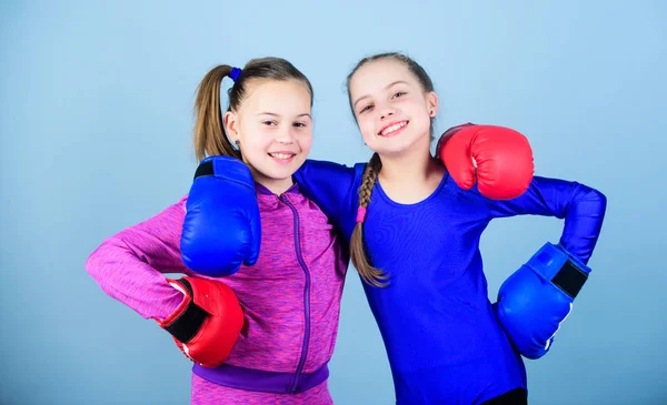 Confident teens. Female boxers. Boxing provide strict discipline. Competitors on ring and friends in life. Girls cute boxers on blue background. Girls in boxing sport. Boxer children in boxing gloves