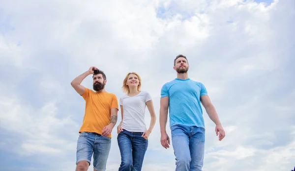 A relaxed style. Group of people in casual wear. Young people in casual style on cloudy sky. Fashion people look casual in summer outfit. Pretty woman and men friends walking outdoor — Stock Photo, Image