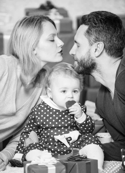 kiss me. father, mother and doughter child. Love and trust in family. Bearded man and woman with little girl. Happy family with present box. Shopping online. Boxing day. Valentines day. Red boxes