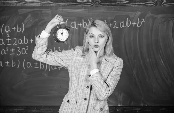 Le importa la disciplina. La profesora sostiene el despertador. Profesora de la escuela. ¿Qué hora es? Horario de clases. Bienvenido año escolar maestro. Salud y régimen diario. Educador lección de inicio — Foto de Stock