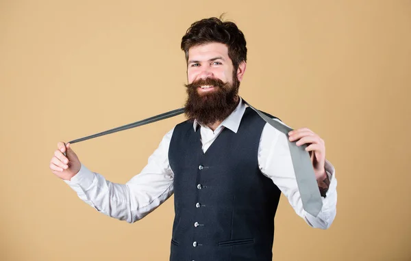 Perfect tie. Fashionable man. Bearded man holding necktie. Brutal guy wearing fashionable classy clothes and accessory. Businessman in fashionable hipster style. Fashion model with fashionable look