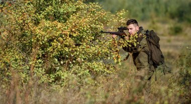 Sakallı ciddi avcı boş zamanlarını avlayarak geçiriyor. Hunter tüfeği tutuyor. Adam kamuflaj giysileri doğa arka plan giymek. Avlanma izni. Avlanmak acımasız erkeksi bir hobidir. Profesyoneller için av ekipmanları