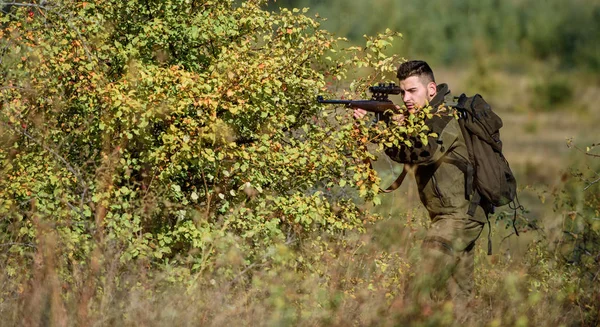 Bärtige ernsthafte Jäger verbringen Freizeit auf der Jagd. Jäger halten Gewehr. Mann trägt Tarnkleidung Natur Hintergrund. Jagdschein. Die Jagd ist ein brutales maskulines Hobby. Jagdausrüstung für Profis — Stockfoto