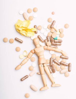 Sağlık ve sorunları. Dokunulmazlık ve tıp vitaminler. Aşırı doz ve ölüm. İlaç reçete. Ahşap insan kukla hap ve tablet yığını üzerinde yatıyordu. Tıp kavramı al. Sağlık ve tedavi