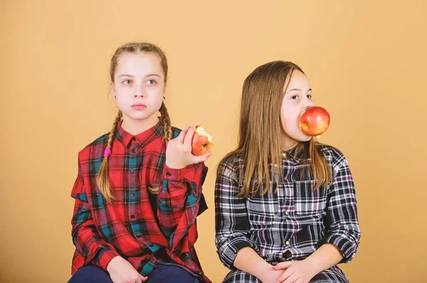 Τρώτε φρούτα για να χαριτωμένο. Μικρά κορίτσια τρώνε μήλα μαζί. Κοριτσάκια να απολαύσετε φρέσκα φρούτα. Χαριτωμένα κορίτσια τρώει υγιεινά σνακ. Αξιολάτρευτο κορίτσια με φυσικές τροφές — Φωτογραφία Αρχείου