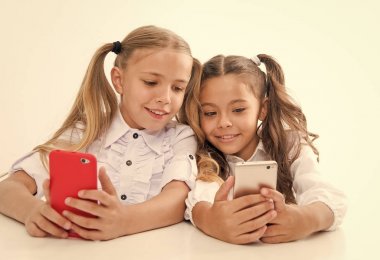 Çevrimiçi yaşam konsepti. Liseli kızlar şirin öğrenciler sosyal ağları kontrol etmek için büyük çapraz ekran akıllı telefonlar kullanır. Şuna bir bak. Arkadaşına mesaj gönder. Çevrimiçi iletişim mesajı. Oyun uygulaması