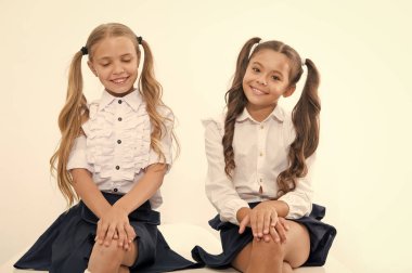 Küçük kızlar okul üniformasıyla gülümsüyor. Küçük kızlar okula geri dönüyor.