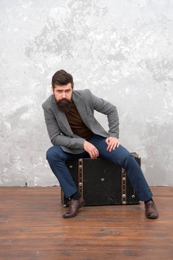 Seyahat etmek için uygun bir yol. iş gezisi macera. seyahat için lüks bavul ile trendy işadamı. vintage ve retro tarzı. grunge arka plan. seyahat çantası ile sakallı adam. moda bakmak