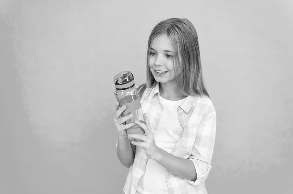 Niño mantenga botella fondo azul. Niño niña pelo largo tiene botella de agua. Concepto de balance hídrico. Saludable e hidratado. Trastornos pediátricos del equilibrio hídrico. Chica se preocupa por la salud y el equilibrio hídrico —  Fotos de Stock