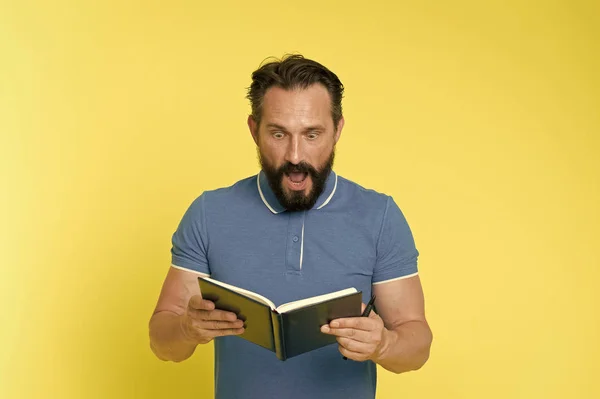 Surprise concept. Bearded man shocked with surprise. Senior man reading book with surprise. Real surprise