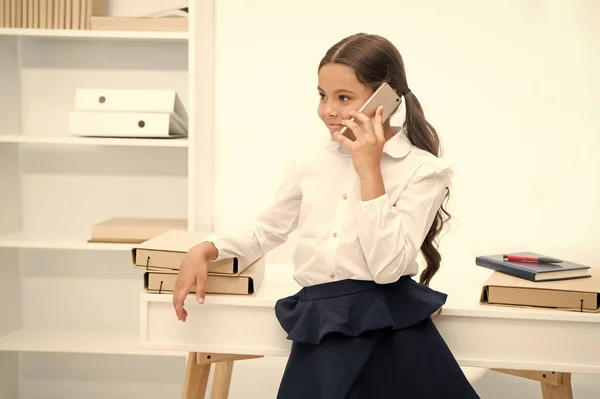 Praten concept. Gelukkig meisje praten op mobiele telefoon. Klein kind smartphone gebruiken op school. Praten over de telefoon tijdens school pauze — Stockfoto