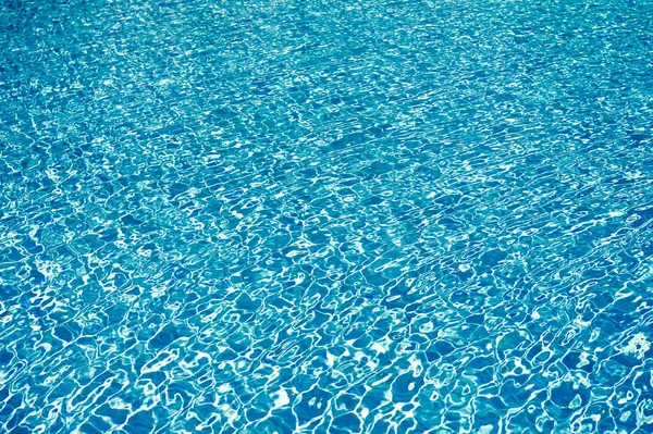 Tekstura tła morskiego. Małe niebieskie fale. Kursy pływania. Przejrzysta czysta woda w basenie. Płynąca powierzchnia wody. Czyściciele basenów. Spa i wellness. Luksusowy ośrodek. Wyposażenie basenu — Zdjęcie stockowe