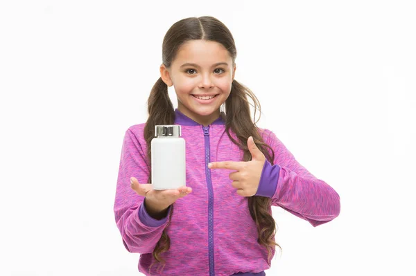 Produktpräsentation. Kleines Kind zeigt auf Tablettenflasche. kleines Mädchen mit Medikamentenpille und Vitaminkomplex. entzückendes Kind mit Vitaminpille. Gesundheitsversorgung. Gesundheitshilfe. Vitamin in Tabletten. Gesundheitspille — Stockfoto