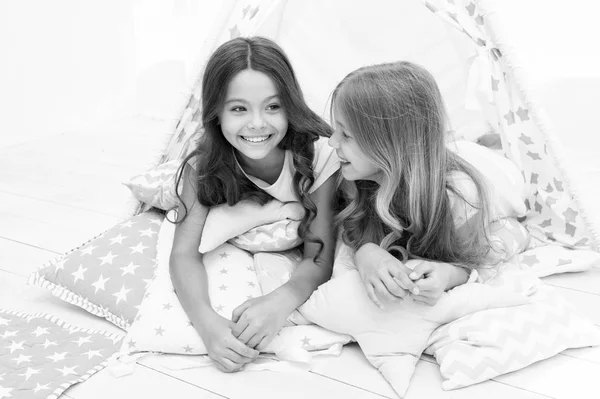 Las niñas en pijama lindo pasar tiempo juntos en el dormitorio. Las hermanas se comunican mientras se relajan en el dormitorio. Tiempo en familia. Comunicación de hermanas. Los niños se relajan y se divierten por la noche. Hermanas de ocio — Foto de Stock