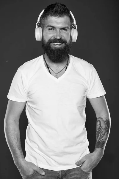 Hair and beard care. Bearded man. Confident and handsome Brutal man. Male barber care. Mature hipster with beard. man in headphones smiling while listening music. online education. man with tattoo
