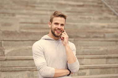 Arayacağım. Sakallı adam akıllı telefon, merdiven ile kentsel arka plan ile yürür. Adam hoş güler yüz smartphone üzerinde konuşuyor. Memnun cevap arama akıllı adam. Hoş sohbet