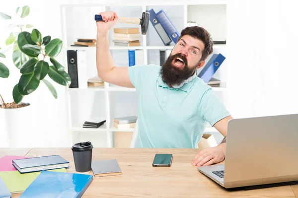 Office life makes him crazy. Businessman with beard and mustache gone mad with hammer in a hand. Frustrated office worker holding hammer poised ready to smash. Angry aggressive businessman in office