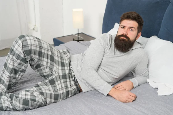 Ještě jednu minutu v posteli. energie a únavy. Hipster s plnovousem chce ráno spát. brutální ospalý muž v ložnici. zralý muž s vousy v pyžamu na posteli. Spí a spí. komfortní postel — Stock fotografie