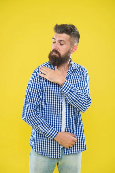 Shake it off. Summer hipster. Brutal bearded hipster in checkered shirt brush dust off shoulder. Male fashion. Pedantic man with beard on yellow backdrop. Mature man. Everything must be perfect