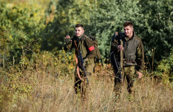 Jagen met vrienden. Jagers vrienden genieten van vrije tijd. Jagers met geweren in natuuromgeving. Teamwork en ondersteuning. Activiteit voor echte mannen concept. Jagers gamekeepers op zoek naar dier of vogel — Stockfoto