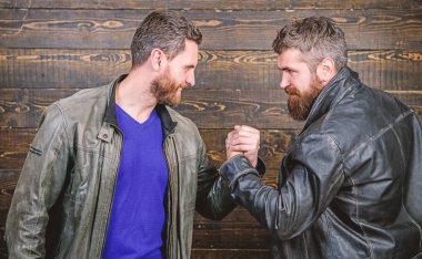 Güçlü el sıkışma. Dostluk vahşi adamlardan. El sıkışma başarılı anlaşma sembolü. İş anlaşması onaylandı. Karşılıklı jest anlamına gelir. Kabul etti. Acımasız sakallı erkekler tokalaşırken deri ceket giyer