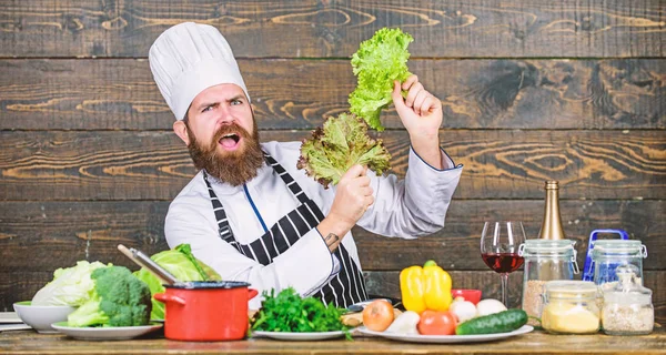Gesunde Ernährung. Rezept für gesunde Ernährung. gesund ernähren. Diätkonzept. Mann trägt Hut und Schürze mit Kopfsalat. Bärtige Hipster-Profiköche halten Salatgrün in der Hand. gesunde vegetarische Rezepte — Stockfoto