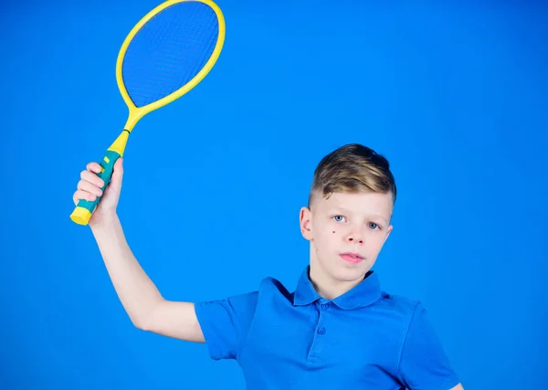 Practicing tennis skills. Guy with racket enjoy game. Future champion. Dreaming about sport career. Athlete kid tennis racket on blue background. Tennis sport and entertainment. Boy child play tennis