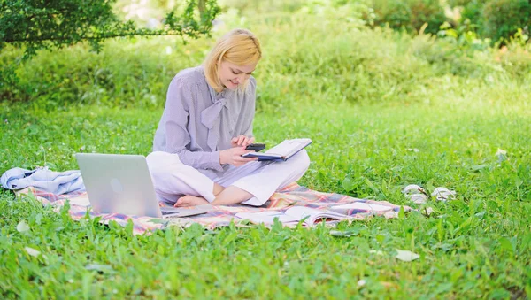 Business lady freelance work outdoors. Become successful freelancer. Woman with laptop sit on rug grass meadow. Girl with notepad write note. Freelance career concept. Guide starting freelance career
