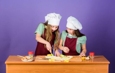 Çocuklar önlük ve şef şapkalar yemek. Aile tarifi. Aşçılık eğitimi. Anneler günü. Zencefilli kurabiye pişiriyor. Kız kardeşler zencefil hamuru yla eğleniyorlar. En iyisi ev yapımı kurabiye. Çocuklar birlikte kurabiye pişiriyor