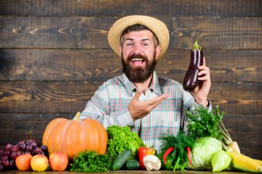 Organik bitkileri büyümek. Evde yetiştirilen organik yiyecekler. Sakallı ahşap arka planlı adam. Organik sebzeli çiftçi. Bahçe ve tarım sistemleri belirli teknikler reçete. Organik bahçecilik kavramı