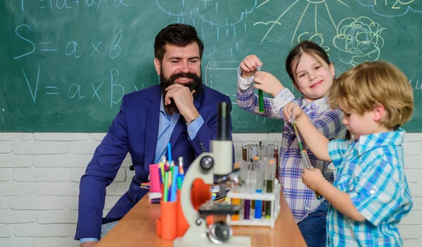 Gelukkige kinderen leraar. terug naar school. biologie onderwijs. Microscoop. Biologie school laboratoriumapparatuur. experimenteren met chemicaliën of Microscoop. Enthousiaste leraar die kinderen helpt. — Stockfoto