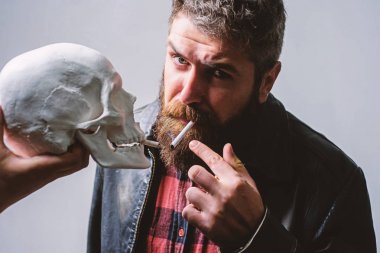 Sigara zararlı olduğunu. Tütün sigara içmeyi alışkanlık vücudunuza zarar getir. Adam ölüm sembolü insan kafatası yakınındaki Sigara İçilmeyen. Zararlı alışkanlıklar. Sigara sağlık zarar ve ölüm. Sağlık yok