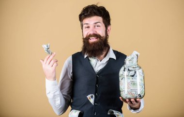 O tamamen zengin. Sakallı zengin bir adam ve yüklü miktarda parası var. Zengin işadamı parayı cam kavanozda saklıyor. Zengin ve para tüccarı