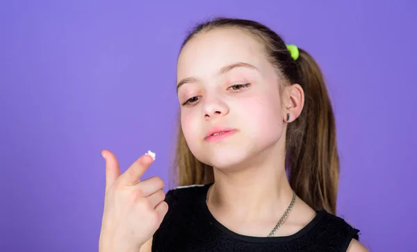 Chico hambriento. Cara sonriente niña sostiene malvaviscos dulces en el fondo violeta mano. Concepto de diente dulce. Niña con el pelo largo le gustan los dulces y golosinas. Caloría y dieta. Dulce incorregible —  Fotos de Stock