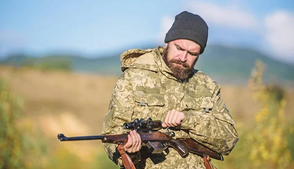 Hunting and trapping seasons. Hunting masculine hobby. Man brutal gamekeeper nature background. Bearded hunter spend leisure hunting. Hunter hold rifle. Focus and concentration of experienced hunter