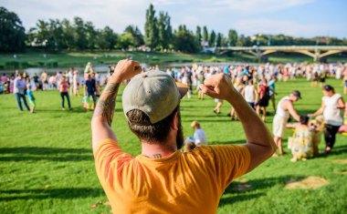 Açık hava konseri. Şehir günü. Müzik festivali. Eğlence konsepti. Yaz festivalini ziyaret et. Adam bayramı ya da festivali kutluyor. Yaz festivali. Kalabalığın önünde sakallı hippi adam. Kitap bileti.