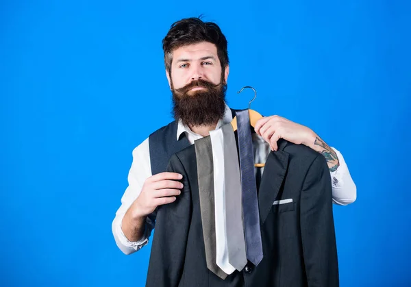 Guy choosing necktie. Perfect necktie. Shopping concept. Shop assistant or personal stylist service. Stylist advice. Matching necktie with outfit. Man bearded hipster hold neckties and formal suit