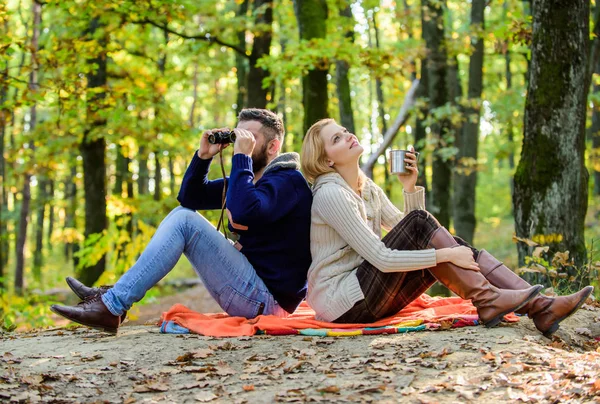 Boldog szerető pár pihentető Park együtt. Pár szerelmes turisták pihentető piknik takaró. Ember távcső és a nő fém bögre élvezik Természetvédelmi Park. Park dátum. Relaxáló a parkban együtt — Stock Fotó