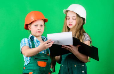 küçük kızlar atölyede birlikte tamir. okul projesi. Mutlu çocuklar. Tabletli kasklı küçük çocuklar. İşçi bayramı. 1 mayıs. Foreman müfettişi. Onarım. bina atölyesi. atölye işçileri