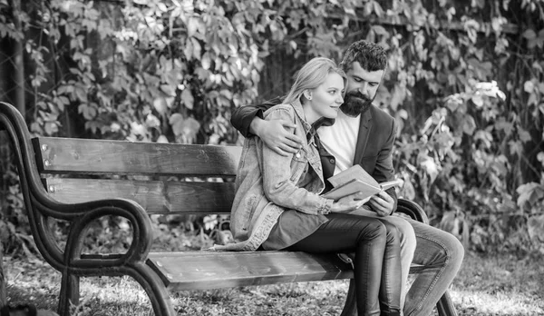 Meeting people with similar interests. Man and woman sit bench park. Read same book together. Couple interested literature. Literature common interest. How to find girlfriend with common interest — Stock Photo, Image