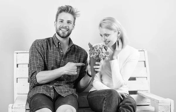 Bloemen voor haar. De favoriete bloemen boeket. Man geeft boeket bloemen aan vriendin. Hij raadt al haar favoriete bloem. Aangename verrassing voor dame. Man vrouw zitten Bank romantische datum turkooizen achtergrond — Stockfoto