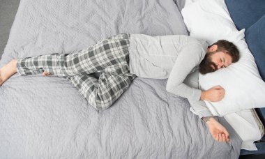 vahşi uykucu adam yatak odasında. Yatakta pijamalı, sakallı olgun bir erkek. Uyuyor ve uyanık. Enerji ve yorgunluk. Sakallı hippi adam sabahları uyur. Derin uykuda. Parti bittiği zaman.