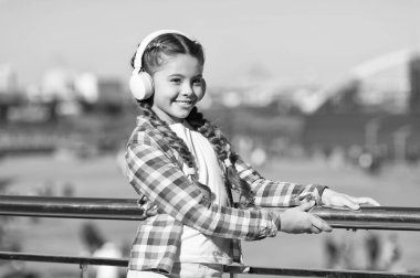 Çocuğunuzu en iyi çocuk kulaklıklarıyla mutlu edin. Kız çocuk açık havada modern kulaklıklarla müzik dinler. Çocuk kulaklıkları test edildi ve en iyiden en kötüye sıralandı. Sesin tadını çıkar