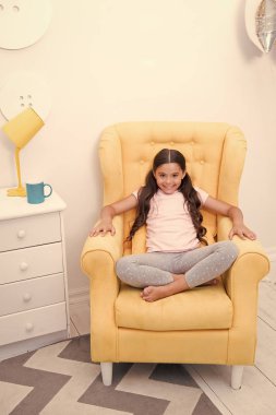 Dinlenmek için rahat bir yer. Kız sevimli sarı koltuğu moda pijama otur. Kız çocuk hazır yatağına git. Moda pijama oturmak ve beklemek birisi kız gülümseyen yüz aşınma söyle onun peri masalı