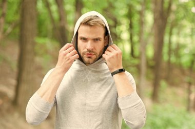 Kendine güveniyorsun. Rahat demek basit demektir. Sakallı, çekici, günlük kıyafetleri olan bir adam. Kendine güveni olan bir adam doğanın arka planından sıyrılmış. Tıraşsız adam yakışıklı ve rahat görünüyor.