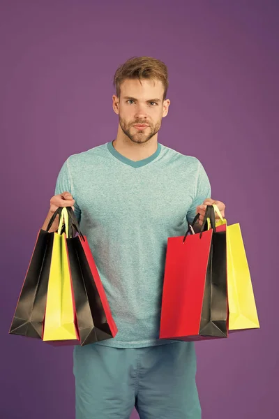 Chancen ergreifen. Ein bärtiges Gesicht hält Einkaufstüten in der Hand. Guy kaufte viel sportliche Kleidung und Accessoires. Mann beim Einkaufen am Schwarzen Freitag. Guy kaufte viele Artikel mit Rabatt. Saisonales Verkaufskonzept — Stockfoto