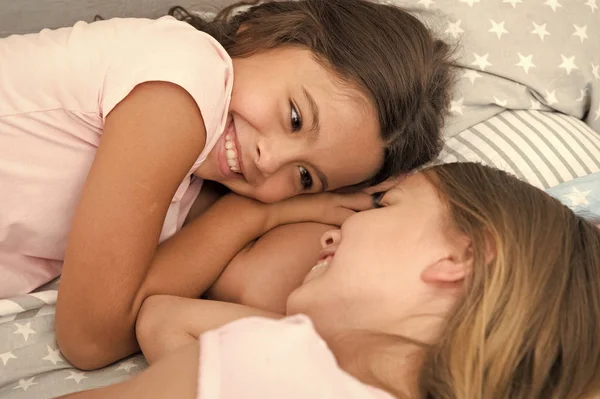 Ευτυχισμένα παιδιά. Ευτυχισμένη μέρα παιδιών με δύο μικρά κορίτσια. Κοριτσάκια που χαμογελούν στο κρεβάτι. έννοια της οικογένειας — Φωτογραφία Αρχείου